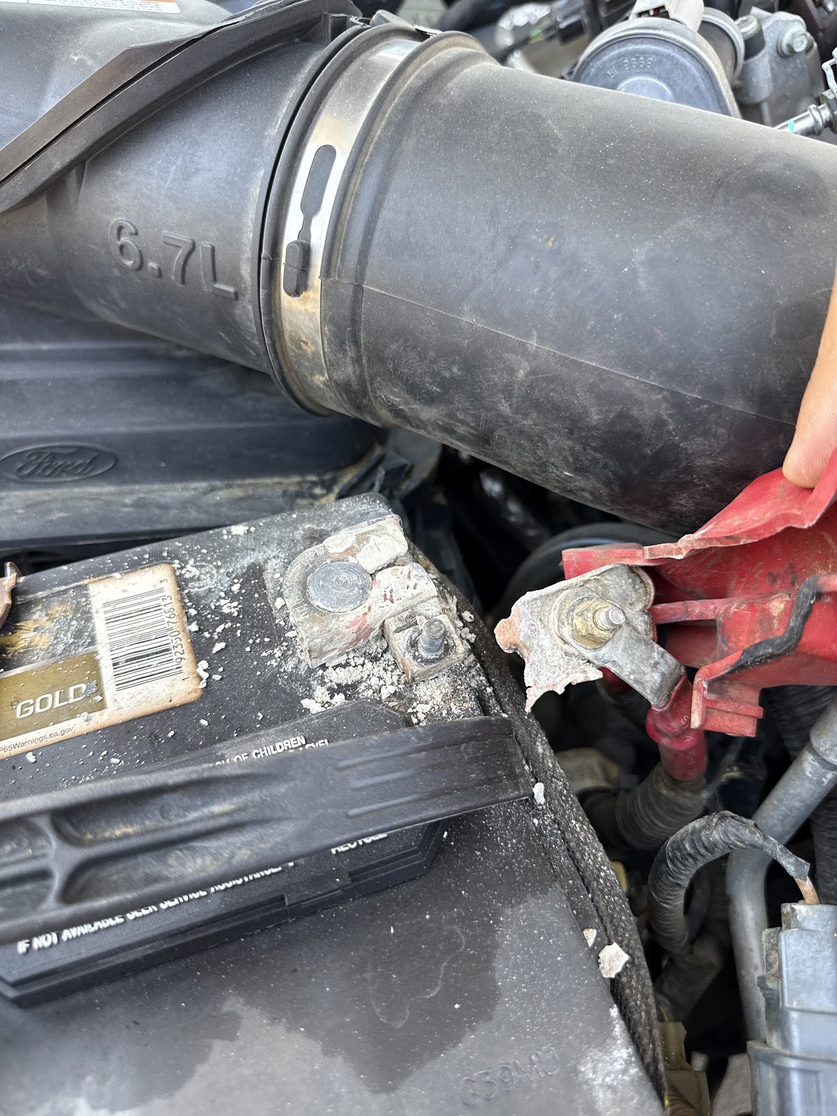 Corroded battery terminal broken off inside a truck engine bay