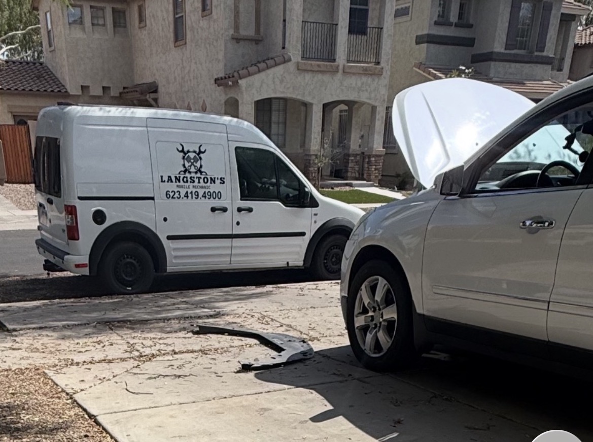 The Langston's van parked on a residential street next to an SUV with its hood raised