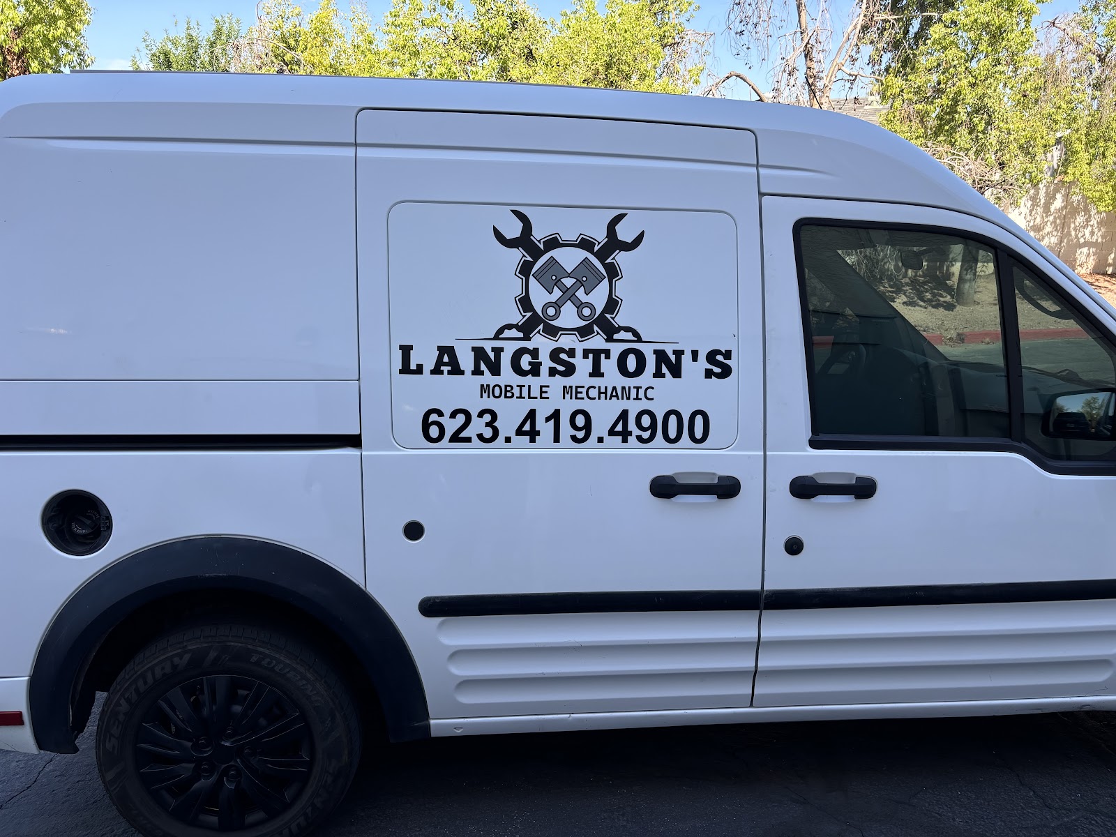 White Langston's Mobile Mechanic van with the crossed-wrenches and pistons logo and phone number on the side doors