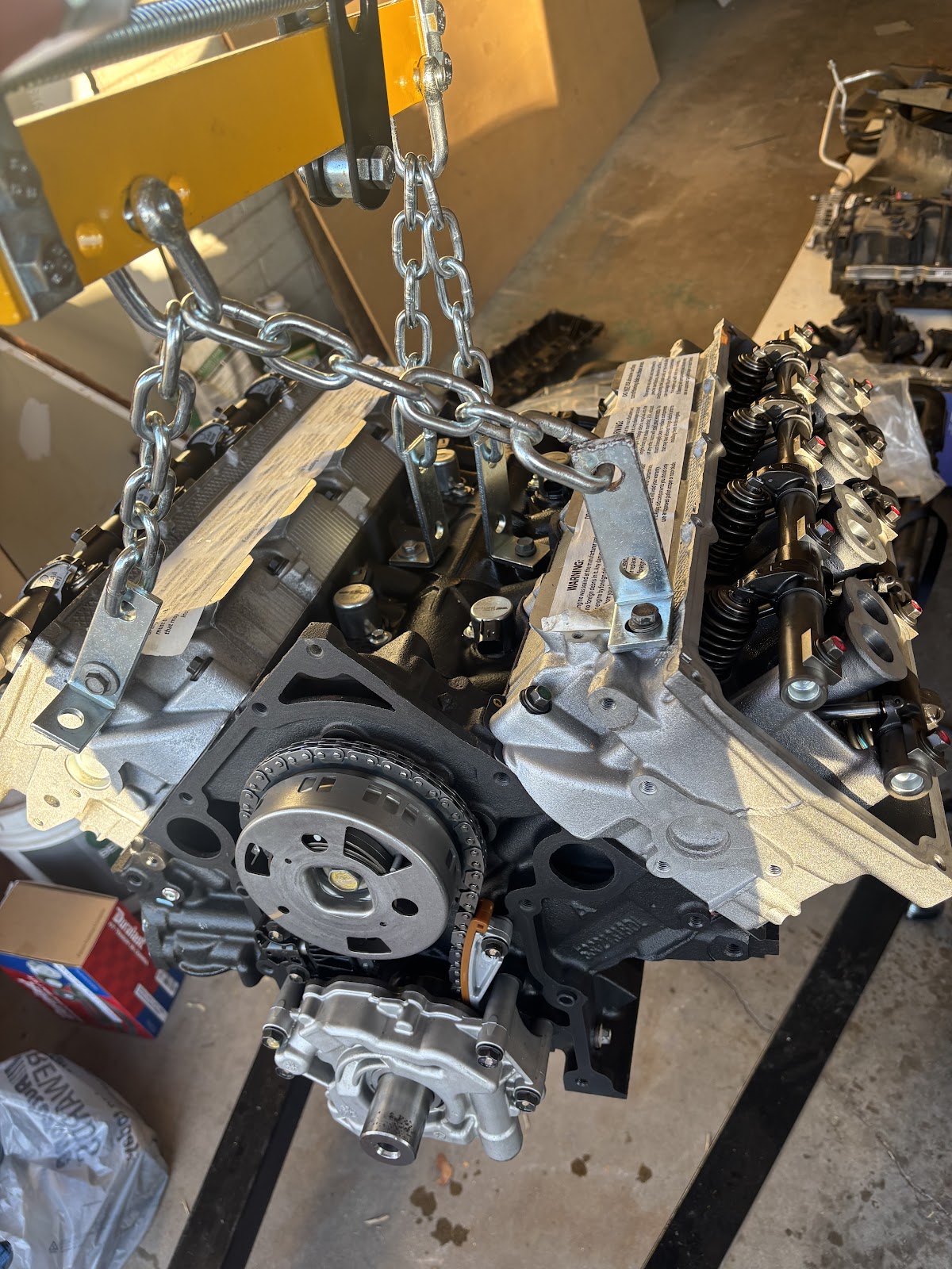 Brand-new engine hanging from hoist chains in a garage